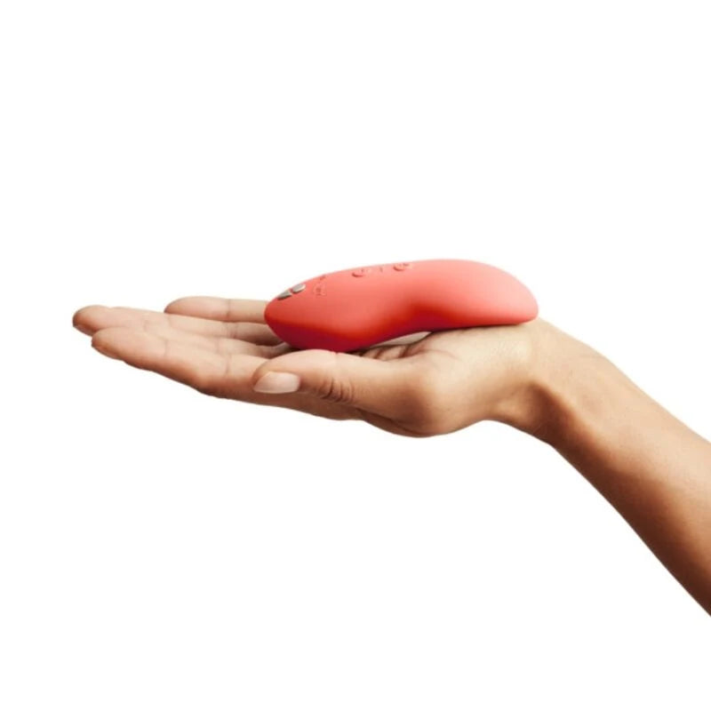 Vibrador We-Vibe Touch X (Coral) — produto pousado na palma da mão